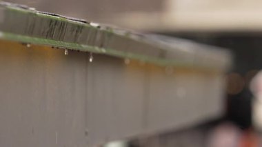 Pencerenin dışında yağmurlu bir gün. Yaz aylarında sıcak yağmur damlaları evin pencere eşiğine düşer.