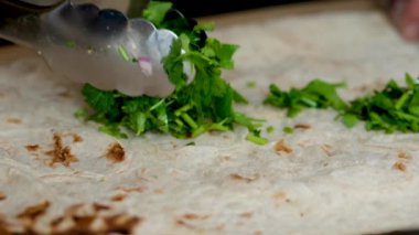 Shawarma için fast food mutfağına dilimlenmiş yeşillikleri koymak. Yavaş çekim