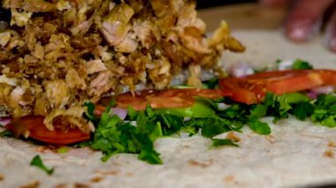 Sosis için fast food mutfağında domatesli ve yeşillikli Pita 'ya et koymak. Yavaş çekim