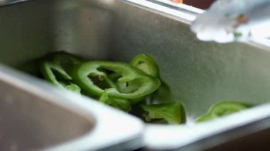 Şef, shawarma için fast food mutfağından dilimlenmiş biber alıyor. Yavaş çekim