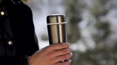 Termo şişesinin kapağını açan kadının yakın görüntüsü