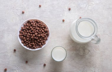 Bardaktaki süt ve arka plandaki çikolata topları..