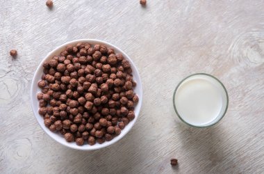 Bardaktaki süt ve arka plandaki çikolata topları..