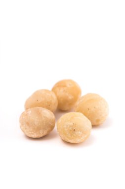 Beyaz arka planda Macadamia fındıkları. Sığ alan derinliğine sahip seçici odak.