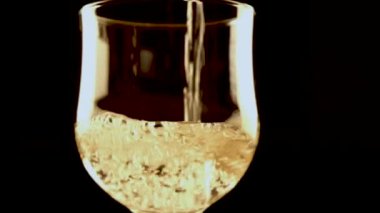 Beyaz şarabı bardağa dolduran kişi, yakın çekim, yavaş çekim.