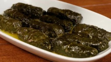 Üzüm yaprağı dolmasına yoğurt döken bir insan..