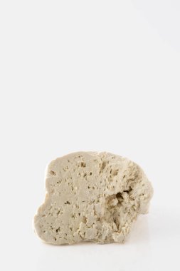 Beyaz arka planda izole edilmiş koyun veya keçi peyniri parçası.