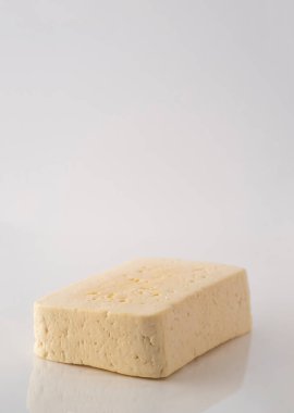 Beyaz arka planda izole edilmiş bir peynir parçası.
