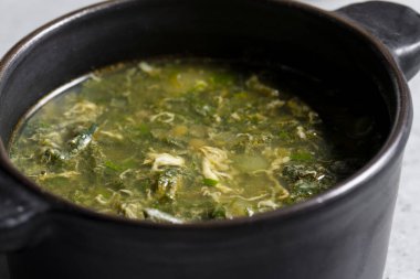 Siyah seramik kapta gri arka planda yeşil doru çorba.