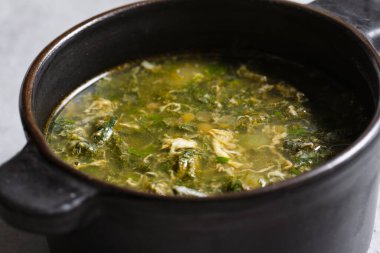 Siyah seramik kapta gri arka planda yeşil doru çorba.