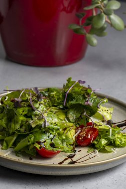 Fresh green salad with cherry tomatoes, arugula and olive oil