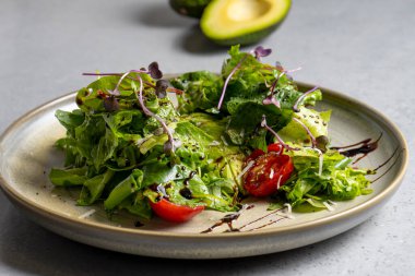 Fresh green salad with cherry tomatoes, arugula and olive oil