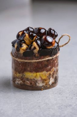 Gri arka planda profiterollü çikolatalı pasta. Seçici odak.