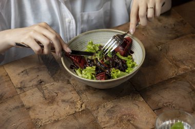 Restoranda salata yiyen bir kadın, yakın plan. Sağlıklı yiyecekler. ciğer salatası