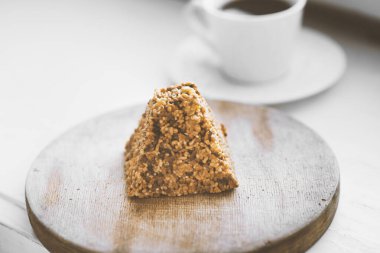 Bir fincan kahve ve tahtanın üzerinde bir parça kek.