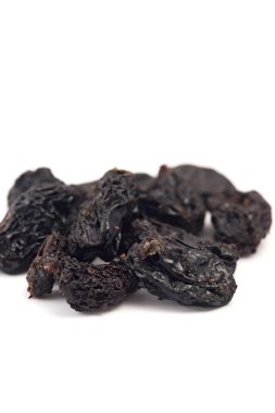 Beyaz bir arka plan üzerinde siyah kuru üzüm. Kuruyemiş.