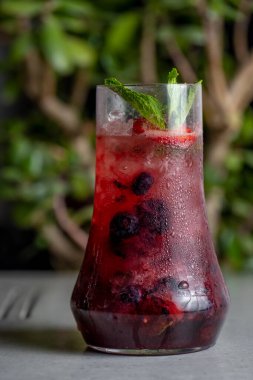 Refreshing summer drink with berries and mint in a glass. lemonade