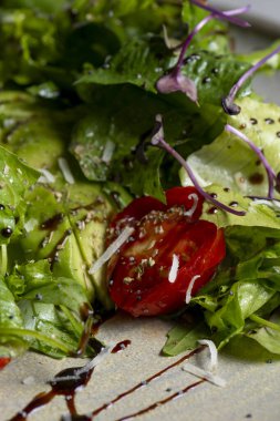 Fresh green salad with cherry tomatoes, arugula and olive oil