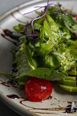 Fresh green salad with cherry tomatoes, arugula and olive oil