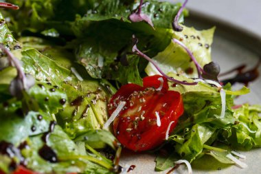 Fresh green salad with cherry tomatoes, arugula and olive oil
