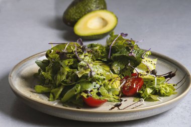 Fresh green salad with cherry tomatoes, arugula and olive oil