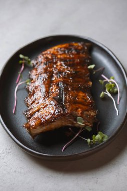 Izgara pirzola, turp ve mikroyeşil tabakta.