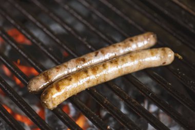 Izgarada alevler ve dumanla ızgara sosis..