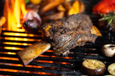 Kızarmış et ve sebzeler alevler ve sebzelerle ızgarada, yakın çekim.