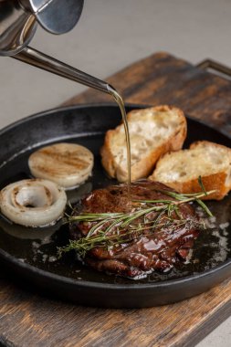 Tost ve biberiyeli kızarmış biftek, zeytinyağı serpiştirilmiş.