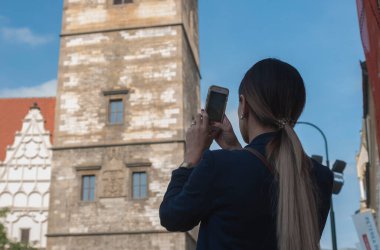 Çek Cumhuriyeti 'nin Prag şehrinde sırt çantalı genç bir kadın selfie çekiyor.