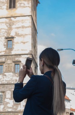 Çek Cumhuriyeti 'nin Prag şehrinde sırt çantalı genç bir kadın selfie çekiyor.