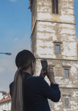 Çek Cumhuriyeti 'nin Prag şehrinde sırt çantalı genç bir kadın selfie çekiyor.