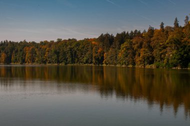 Gölü ve sonbahar ağaçları olan güzel bir manzara.
