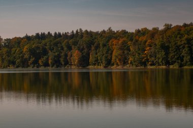 Gölü ve sonbahar ağaçları olan güzel bir manzara.