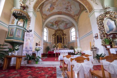 Catholic church interior with pews, statues, frescoes and altar