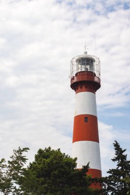 Poti, Georgia 'da bulutlu mavi gökyüzü arka planında kırmızı ve beyaz deniz feneri.