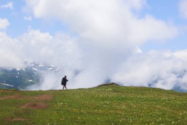 One tourist against the backdrop of mountains and clouds in Gomismta, Guria, Georgia.