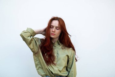 Uzun kızıl saçlı genç bir kadın şehirde poz veriyor. Çilli yüz, yakından, doğal güzellik. Açık havada fotoekonomik durgunluk