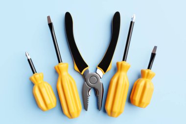 3D illustration of a yellow  screwdrivers and pliers in cartoon style on a monochrome  isolated background. Hand carpentry tool for DIY shop.