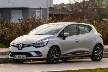 Side, Turkey -January 21, 2023:   white  Renault Clio  is parked  on the street on a warm summer day against the backdrop of a  building