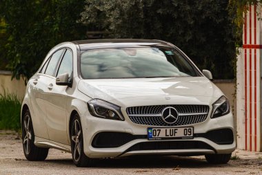 Side, Turkey -January 22, 2023:    white Mercedes-Benz A-class   is parked  on the street on a warm  day 