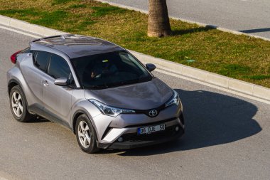 Side, Turkey -January 22, 2023:  silver  Toyota Ch-r   is driving fast   on the street on a  summer day against the backdrop of a palms