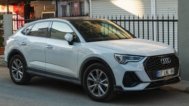 Side, Turkey -January 23, 2023:       white  Audi Q3   is parking  on the street on a  summer day 