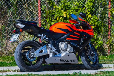 Side, Turkey -January 23, 2023:    A  black motorcycle stands in a parking against the backdrop of street