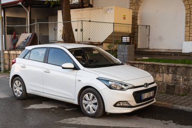 Side, Turkey  january 27 2023:   white  Hyundai i20  is parking  on the street on a  summer day   clipart