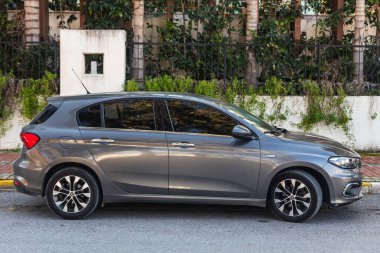 Yana, Türkiye - 23 Ocak 2023: Gri Fiat Egea bir yaz günü sokağa park ediyor 