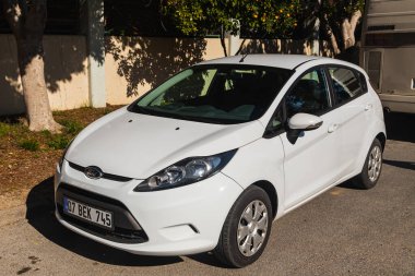 Yana, Türkiye - 23 Ocak 2023: Sıcak bir sonbahar gününde beyaz Ford Fiesta sokağa park edildi 