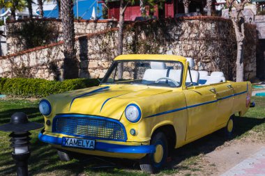 Taraf, Türkiye - 23 Ocak 2023: 5 yıldızlı bir otelin çiçek tarhında üstü açık sarı bir araba