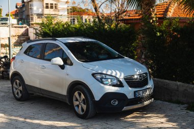 Yana, Türkiye - 23 Ocak 2023: Beyaz Opel Mokka sıcak bir yaz gününde sokağa park edildi 