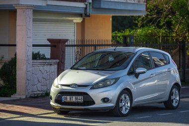 Yana, Türkiye - 05 Şubat 2023: Gümüş Ford Fiesta sıcak bir sonbahar gününde sokağa park edildi  